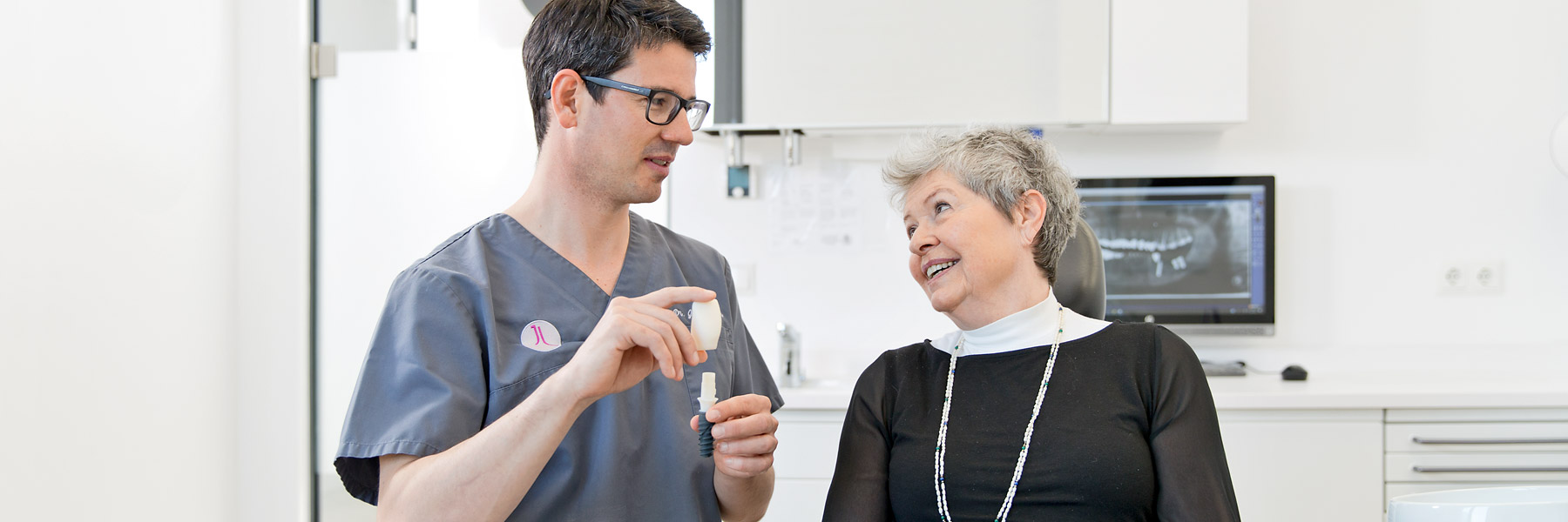 Zahnarzt Regensburg Dr. Lehner zeigt einer Patientin ein Zahnmodell