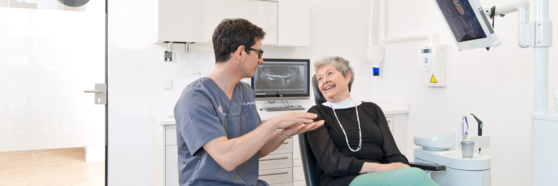 Zahnarzt umkreis Regensburg Dr. Lehner spricht mit einer Patientin am Stuhl