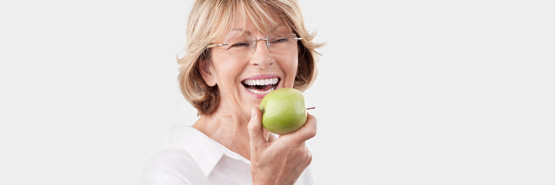 Dame mit schönen Zähne und einen Apfel in der Hand lacht