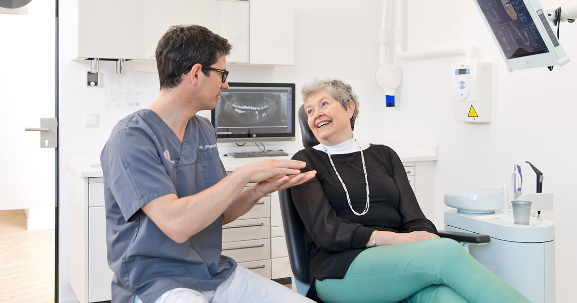 Zahanrzt Regensburg & Regenstauf Dr. Lehner erklärt einer Patientin ihre Behandlung